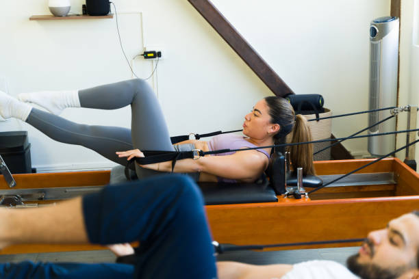 istock Focused duo exercising on pilates reformer beds 2120572013