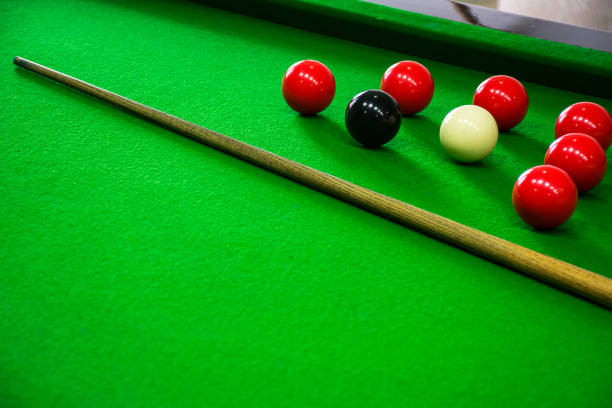 istock pool cues and balls sitting on a green table with red, white, and blue 2120655016