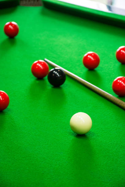 istock some pool balls, cues and a cue standing on the pool table 2120655033