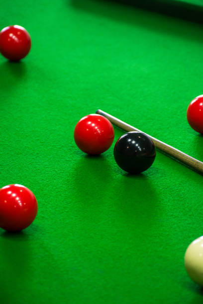 istock balls arranged around on a green billiards table next to cues 2120655542
