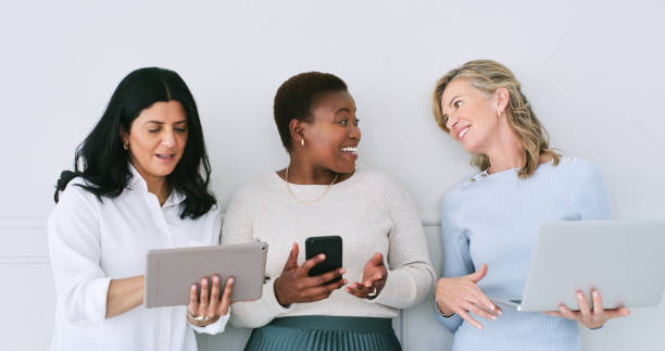 istock Diverse, women and smile with technology in studio for research on internet, share ideas and creativity. Happy, coworker and online as interior designers with sharing, teamwork and collaboration 2120688630