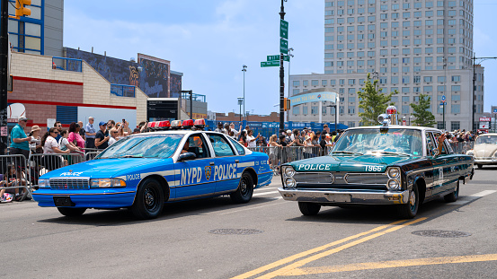 Coney Island, New York City, USA - June 17, 2023: Antique police cars at Mermaid Parade, Surf Avenue, the largest art parade in the nation.