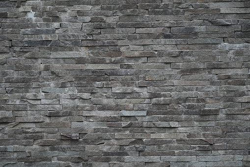Texture of natural stone Sandstone. The material of natural origin is used for cladding facades of walls, fences and paths in construction. Trendy Image, Toned in Color of the year 2022, Very Peri.