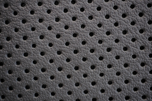 Car seat black perforated natural leather texture extreme close-up