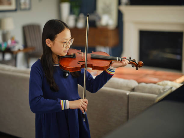 istock Young Girl Practicing Violin in a Home 2120731193