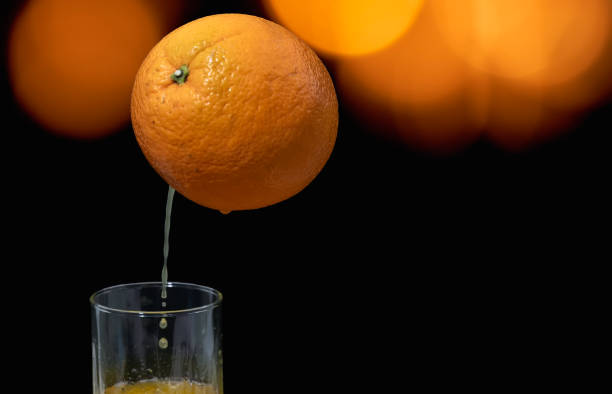 freshly squeezed orange juice. - orange black horizontal saturated color стоковые фото и изображения