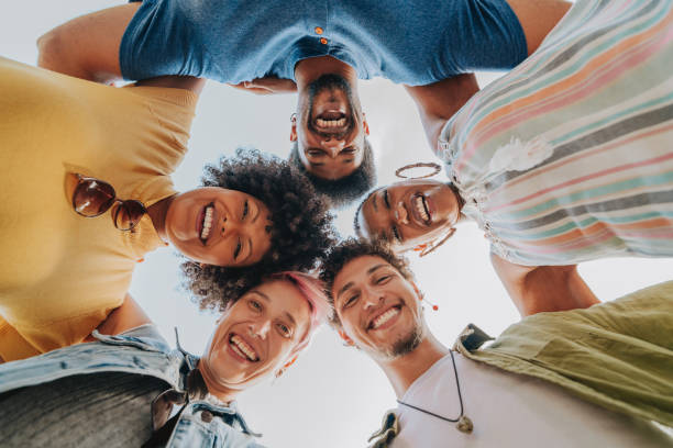 Group of happy friends hugging each other looking at camera