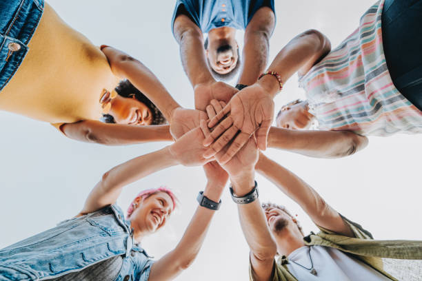 istock Group of happy friends joining hands 2120762558