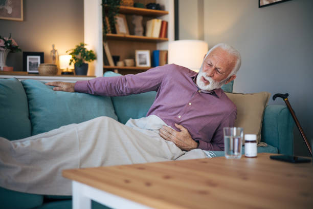 istock Sick old man laying down at sofa 2120771388