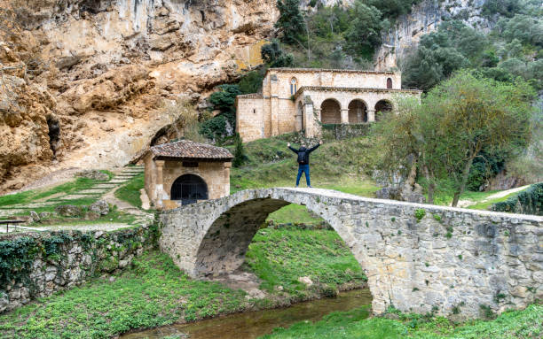 istock Euphoric man with arms raised on an ancient arched bridge 2120821813