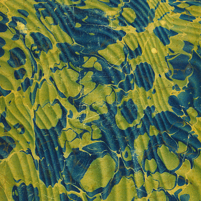 Close up of antique 19th century blue and green paper marbling texture full frame.