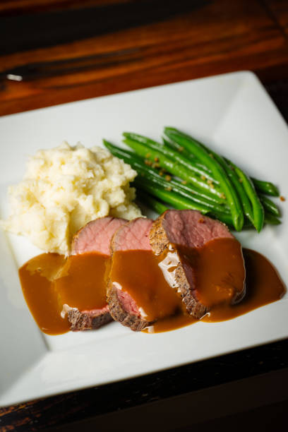istock pouring brown gravy sauce on roasted beef 2120836543