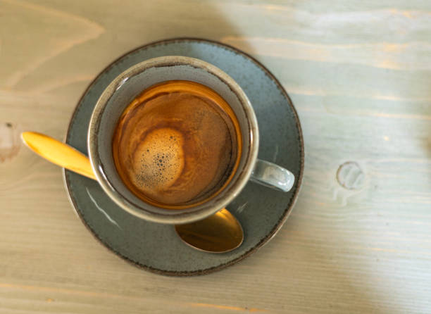 istock black coffee in a cup with a golden spoon, top view 2120890407
