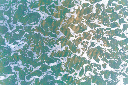 close up top view of the texture of the seawater on the shore, background water sea natural view. Summer concept