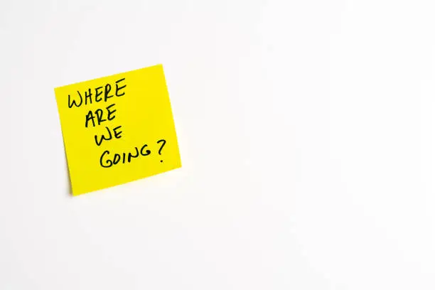 The words Where Are We Going on a yellow sticky note posted on an isolated white background