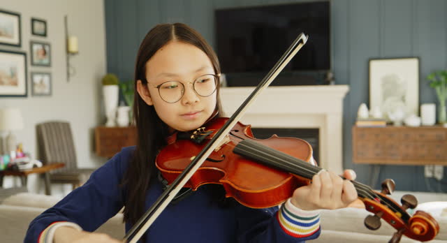 Young Girl Practicing Violin in a Home