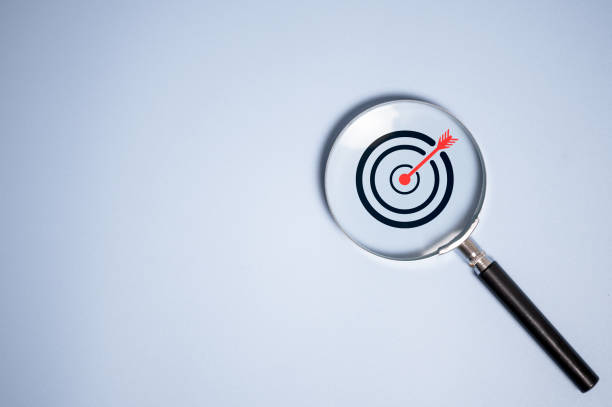 istock Target board inside vintage magnifying glass  for focus business objective on blue background and copy space. 2120989656