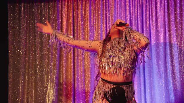 Drag queen sings playback on stage