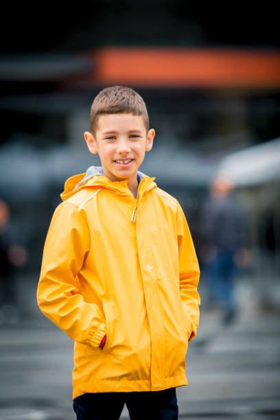 in blue raincoat a little boy happytime under rain with transparent umbrella