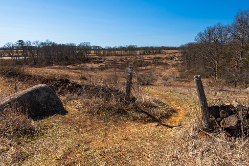 Two old, wooden gate fence posts on a field in the Gettysburg National Military Park on a sunny winter day