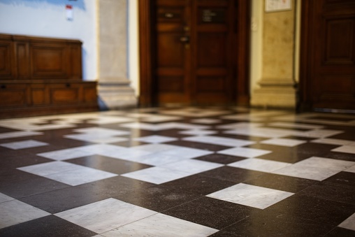 Selective focus of a checkered floor in a vintage hallway with blurred background.