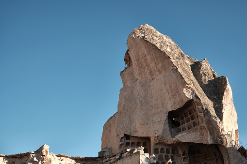Cave dwelling carved in limestone rock formations. Fairy chimney at Cappadocia. Rock hoodoo in Goreme village, Nevsehir province, Turkiye. UNESCO World Heritage site