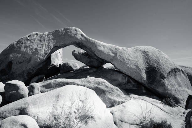 Black and white wide angle photograph of arch rock at Joshua tree national Park.