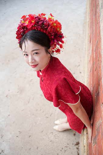 One person of aged 20-29 years old who is beautiful with black hair latin american and hispanic ethnicity young women barista standing in front of white background wearing apron and high heels who is cheerful and holding hot chocolate