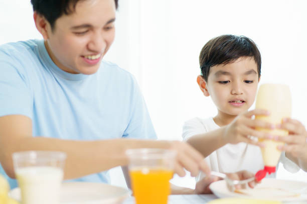 istock Father and son making a breakfast together. 2121353137