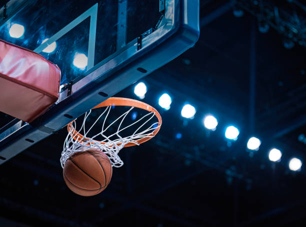 baloncesto anotando una canasta a medida que pasa por el aro - canasta baloncesto fotografías e imágenes de stock