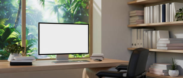 istock A home office features a computer on a desk against the window with a view of a tropical forest. 2121387496