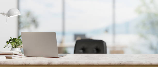 istock A back view image of a laptop computer on a white marble desk in a modern spacious office. 2121387906
