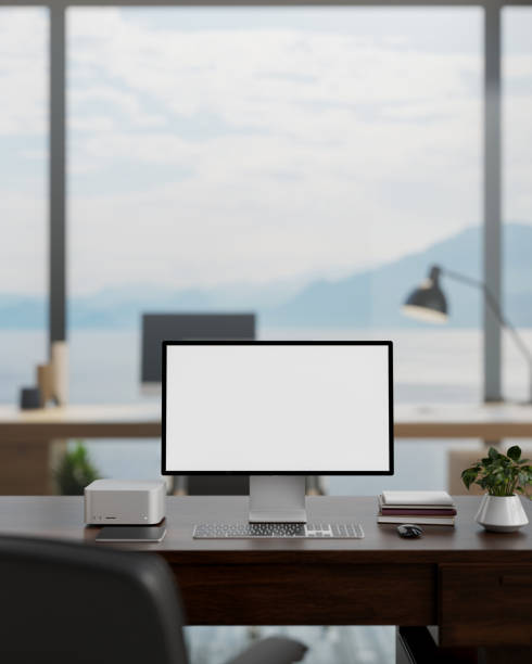 A white-screen computer mockup on a desk in a modern spacious office with a beautiful nature view.