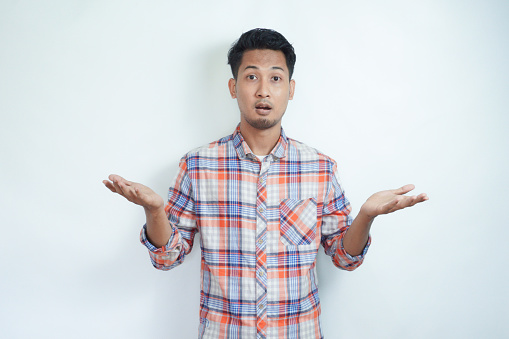 Adult Asian man showing confused expression with both hand doing unbalance gesture