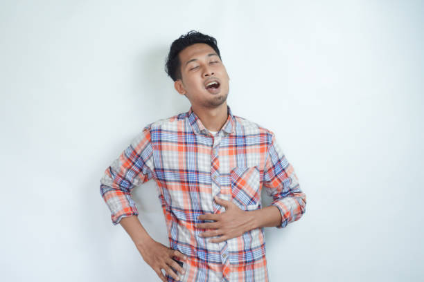 istock Adult Asian man touching his belly with relieved expression 2121403811