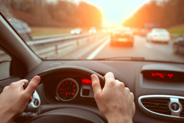driving on highway road, closeup hands of car driver on steering wheel, road trip driving on highway road, closeup hands of car driver on steering wheel, road trip at sunset steering wheel stock pictures, royalty-free photos & images