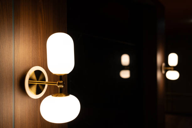 istock Lamp with the light bulb inside shining on the wall background in the dark room with copy space. 2121500936
