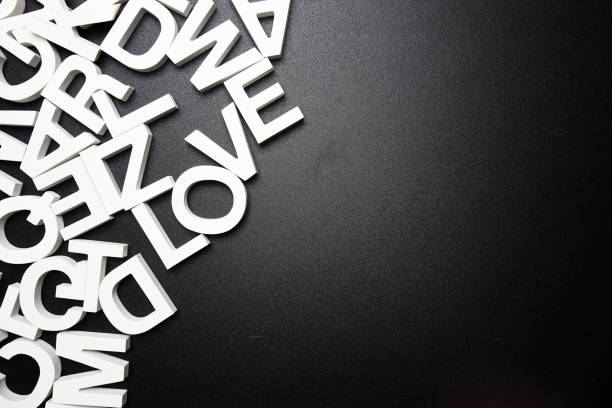 istock Top view random wooden alphabet letters on black background 2121532297