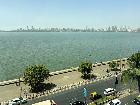 Marine Drive, Mumbai, Maharashtra, India - March, 15 2024: Stock photo showing elevated view of multilane highway running along coastline at Marine Drive, Mumbai, India with a manmade, sea defence of a concrete, seawall, which has been constructed to prevent flooding of the promenade of  during high tide.