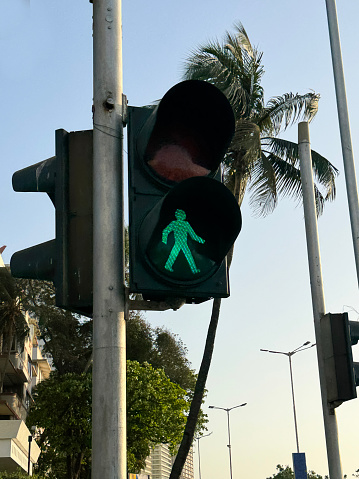 Mumbai, Maharashtra, India - March, 15 2024: Stock photo showing close-up view of pelican crossing with illuminated green man indicating pedestrians should prepare to cross the road.