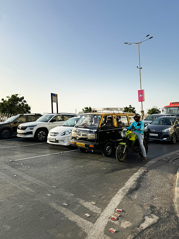 Marine Drive, Mumbai, Maharashtra, India - March, 15 2024: Stock photo showing close-up view of multilane highway running along coastline at Marine Drive, Mumbai, India. Vehicles including cars, motorbikes, taxis and lorries stopped waiting for a red traffic light to turn green.