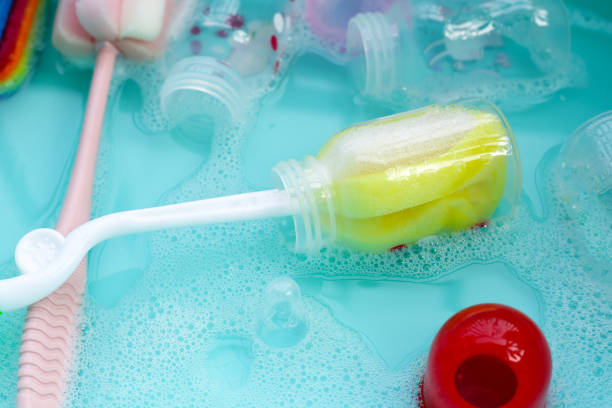 istock Wash baby bottles in plastic blue basin 2121751310