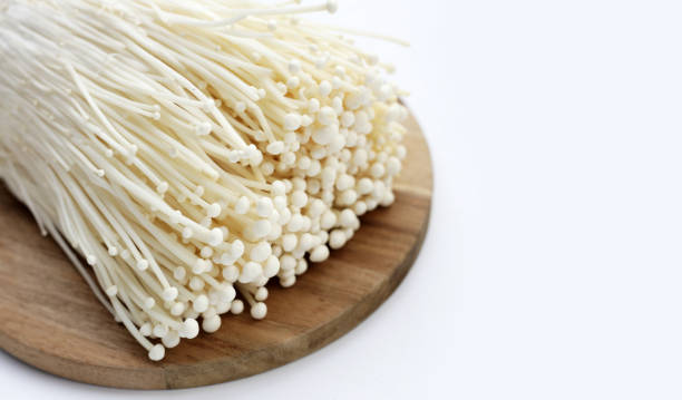 istock Fresh Enoki mushrooms on wooden cutting board 2121755442