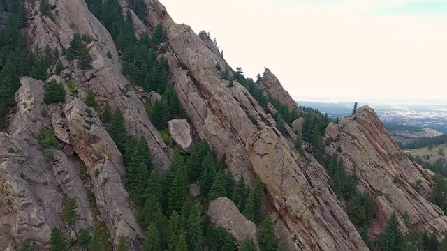 A spectacular 4K drone shot of the Flatirons, striking slanted rock formations that jut out of the Rocky Mountain foothills, just outside Boulder, Colorado, USA.