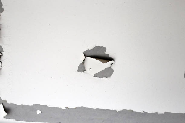 istock White color paint peeling off on ceiling house. Under the roof 2121774614