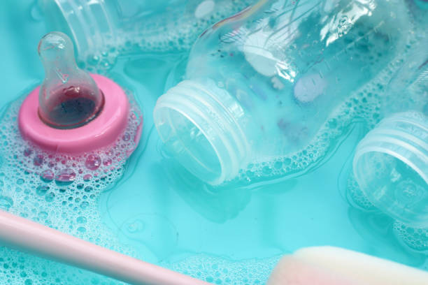 istock Wash baby bottles in plastic blue basin 2121776678