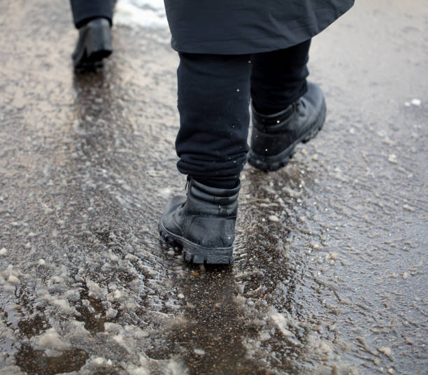 istock A man walks through a puddle on a cold winter day 2121786165
