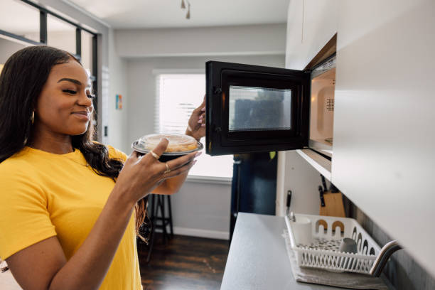 two old white and black microwave on white floor, white wall background, technology, object, ferniture, electricity; copy space