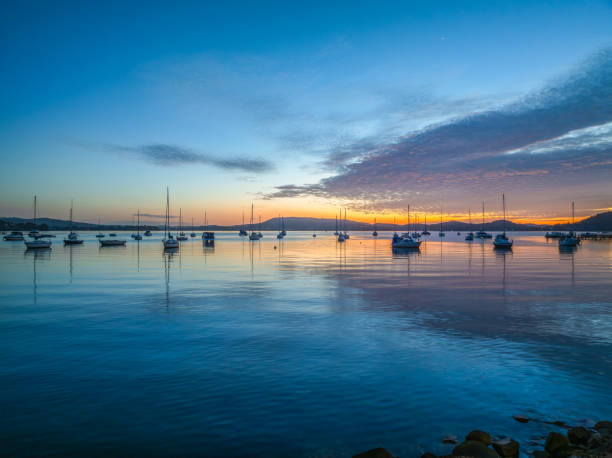 istock Sunrise over the water with boats and reflections 2121801151