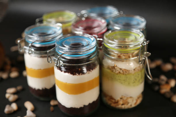 A variety of jars filled with food neatly arranged and displayed on top of a table.